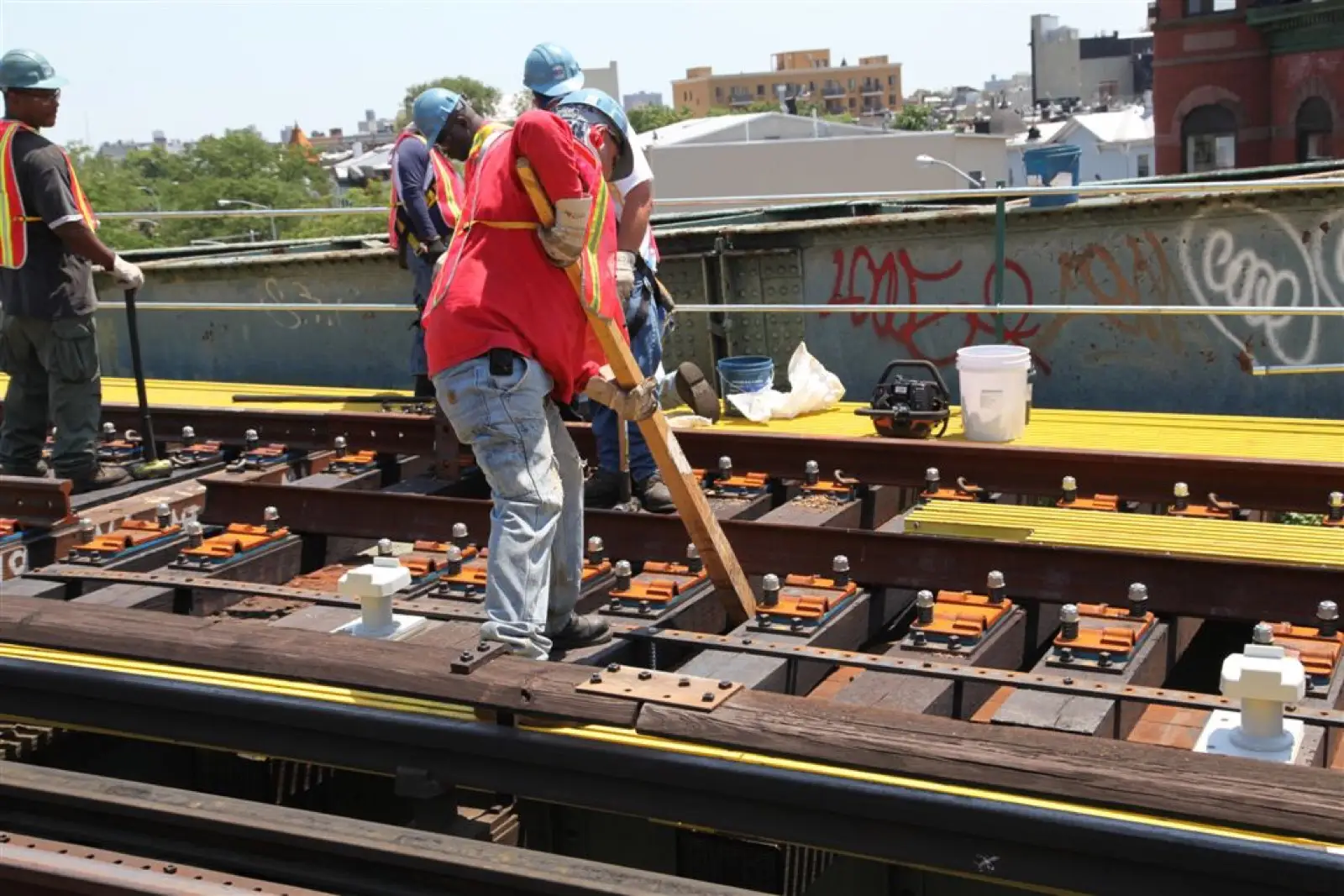 Track crew driving timber while repairing an elevated railway