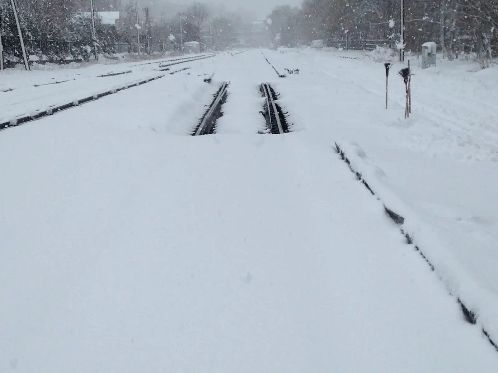 Snow-covered railway switch with rails still readable through the snowpack